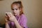 a little girl is engaged online in the application on the phone.