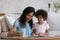 Little girl engaged in painting class with mother at home