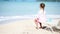 Little girl enjoying on sunbed on white beach