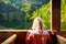 Little girl enjoying a view of deep green waters of Konigssee while traveling by electric boat