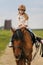 Little girl in equestrian helmet riding a horse