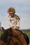 Little girl in equestrian helmet riding a horse