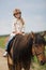 Little girl in an equestrian helmet riding a horse. Girl on a horse walk in nature