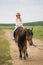 Little girl in an equestrian helmet riding a horse. Girl on a horse walk in nature