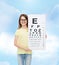Little girl in eyeglasses with eye checking chart
