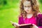 Little girl in eyeglasses reading the book in autumn park. Education concept.