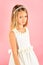 Little girl in fashionable dress, prom. Fashion model on pink background, beauty. Look, hairdresser, makeup. Child girl