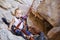 Little girl fastened to rock climbing gear