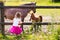 Little girl feeding baby horse on ranch