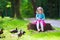 Little girl feeding ducks in a park