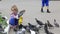 Little girl feeds pigeons in the park