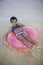 Little girl floating on a pink raft
