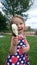 Little girl in flowery dress eats mint choc chip ice-cream