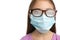 Little girl with foggy glasses caused by wearing disposable mask on white background, closeup. Protective measure during