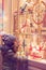 Little girl in front of window of a store, full of wrapped gifts