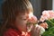 Little girl with funny face smelling spring flowers