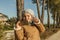 Little girl with funny kiss face and grey bonnet taking a selfie