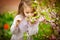 Little girl in garden sniffs almond bush