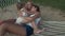 Little girl gently hugs mom and sister in hammock stock footage video