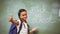 Little girl gesturing thumbs up in classroom