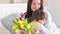 A little girl gives a bouquet of yellow and purple tulips to her mother. Affectionate loving hugs of daughter and mom on