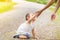 Little girl gives hand to her mother. MOM helps baby stand up