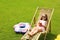 Little girl with glass of juice on deck chair at backyard