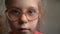 Little girl in glasses with eye problem
