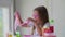 A little girl with glasses is played with a homemade pink slime. Kids hands playing slime toy.