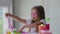 A little girl with glasses is played with a homemade pink slime. Kids hands playing slime toy.