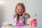 A little girl with glasses is played with a homemade pink slime. Kids hands playing slime toy