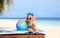 Little girl with globe and toy plane on beach