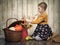 Little girl goes through autumn bouquet of flowers of sunflower, ears of wheat.