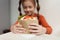 Little girl going to eat pita souvlaki in Greek restauant. White elementary age kid holding big tasty sandwich in close up