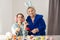 Little girl with grandmother dyeing Easter eggs