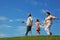 Little girl and grandparents running on hill