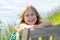 Little girl in green dress poses on a park bench