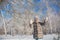 Little girl in grey jacket walks in winter park in sunny day