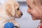 Little girl with a grin meeting her new puppy at the animal shelter