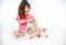 Little girl grooming and combing a cat with a brush at home on a white background. Caring for children and cats.