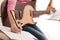 Little girl with guitar writing music notes indoors