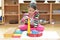 Little girl hand building tower made of montessori educational