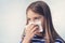 Little girl with handkerchief. A cold girl blows her nose in a white rag on a blue background. Diseases and colds. Rhinitis snot