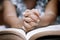 Little girl hands folded in prayer on a Holy Bible