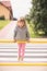 Little girl hanging on a street barrier