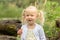 The little girl harvests carrots and eats carrots