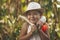 A little girl harvests vegetables in the backyard. Smiling and hugging daikon and white eggplant