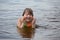 A little girl has fun playing in the river diving and splashing