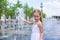 Little girl have fun in open street fountain at