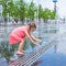 Little girl have fun in open street fountain at